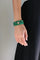 Stacked emerald quartz beaded bracelets with gold evil eye charm on wrist