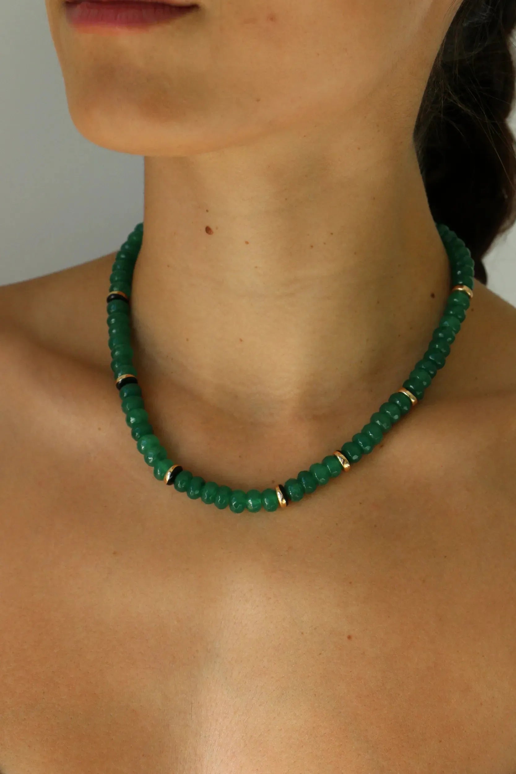 Emerald quartz beaded necklace with gold accents worn on neckline