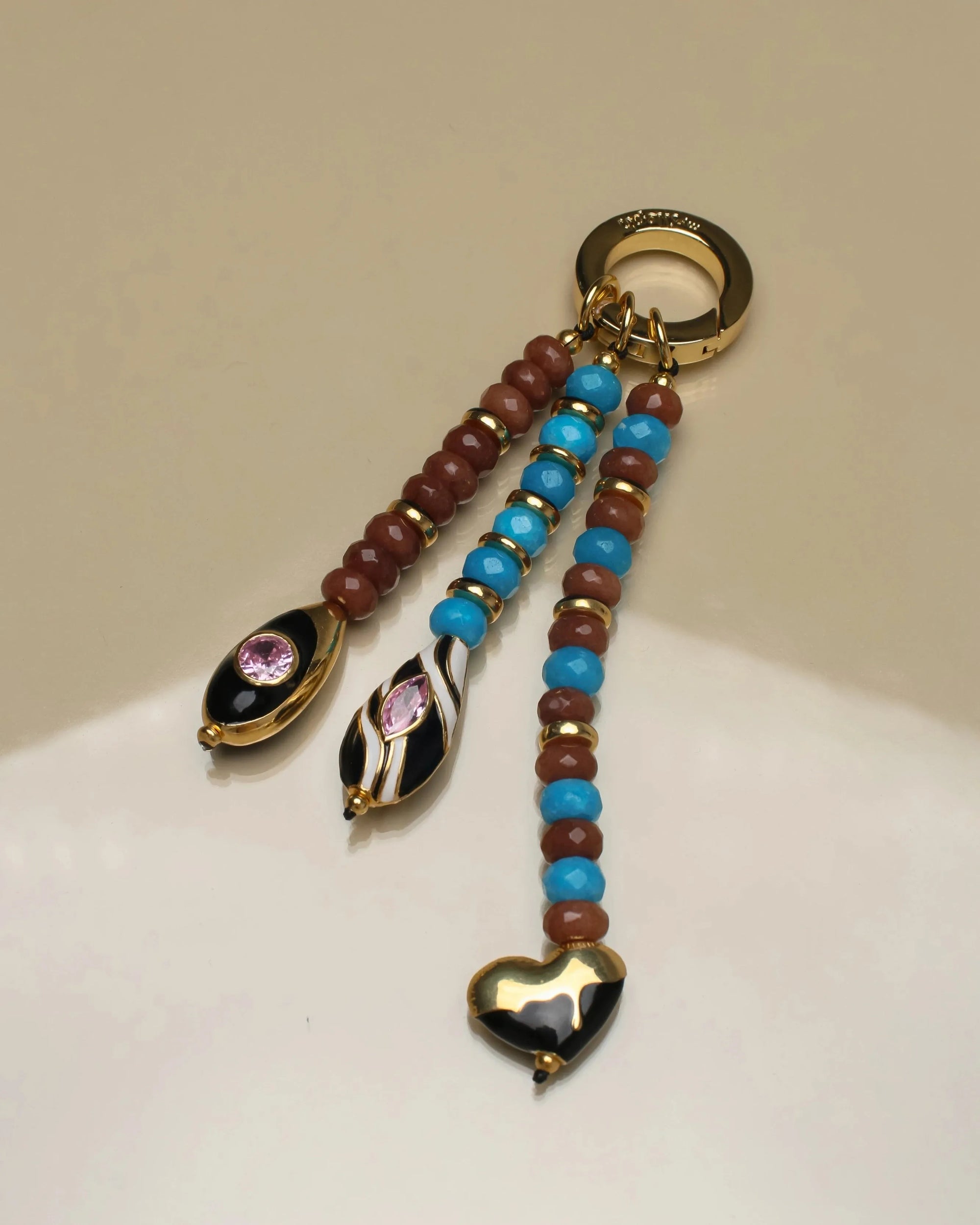 Close-up of the Liora Bag Charm in Azure &amp; Espresso, featuring semi-precious azure and espresso beads with gold accents and heart and teardrop charms.
