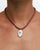 Model wearing MyAleph Lola Cord Necklace in Sunset with bordeaux cord, rose evil eye pendant, and white stone detail