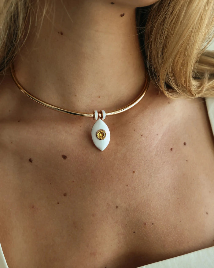 Close-up of the necklace worn with an off-shoulder white top, showcasing the charm centered at the collarbone.