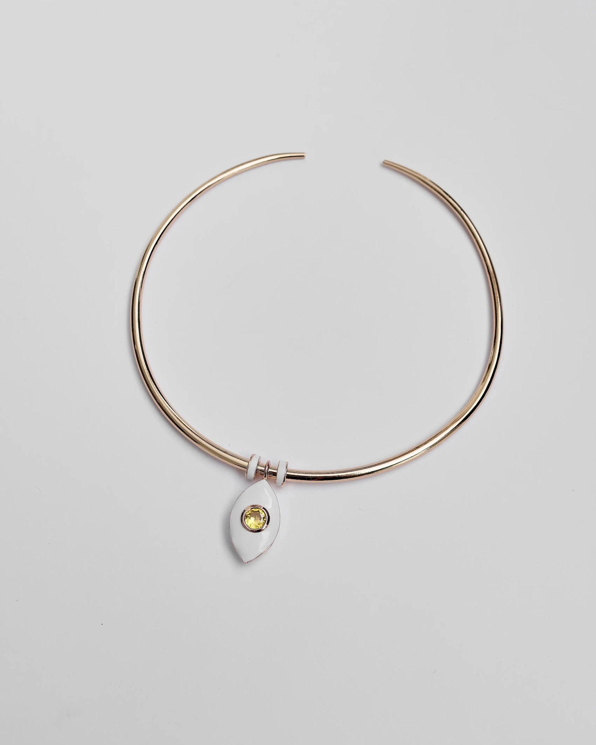 Overhead image of the necklace laid flat, highlighting the yellow CZ crystal and gold-accented dividers.