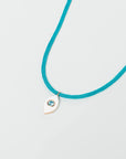 MyAleph Lola Cord Necklace with turquoise blue cord, gold evil eye pendant, and white background