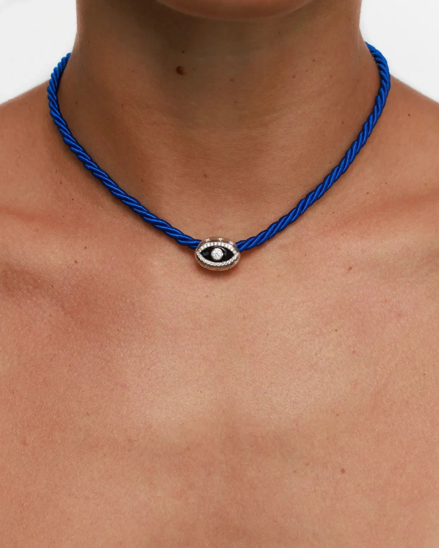 Model wearing MyAleph Luna Cord Necklace with cobalt blue cord and silver evil eye pendant