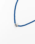 MyAleph Luna Cord Necklace with cobalt blue cord, silver evil eye pendant, and white background
