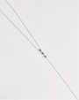 Mayra Evil Eye Body Chain in silver dipped laid flat on white surface with three black enamel evil eye charms at center