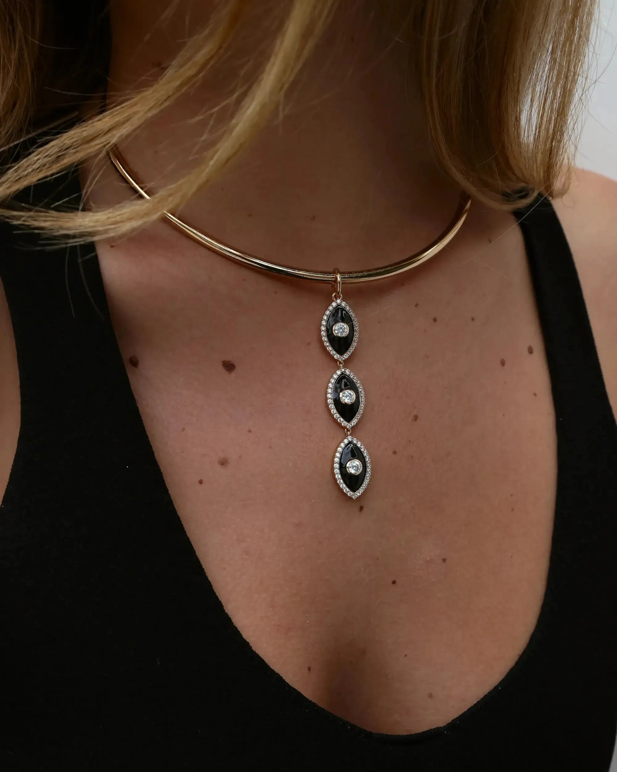 Mayra Evil Eye Necklace with three pendants on a person wearing a black top