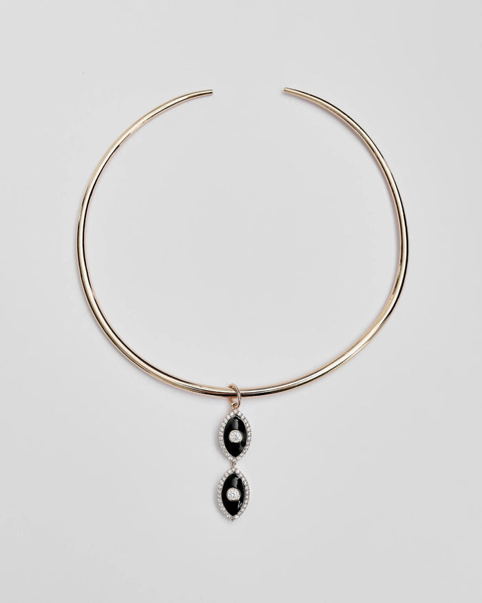Gold collar necklace with two black enamel evil eye charms displayed flat against a white background.