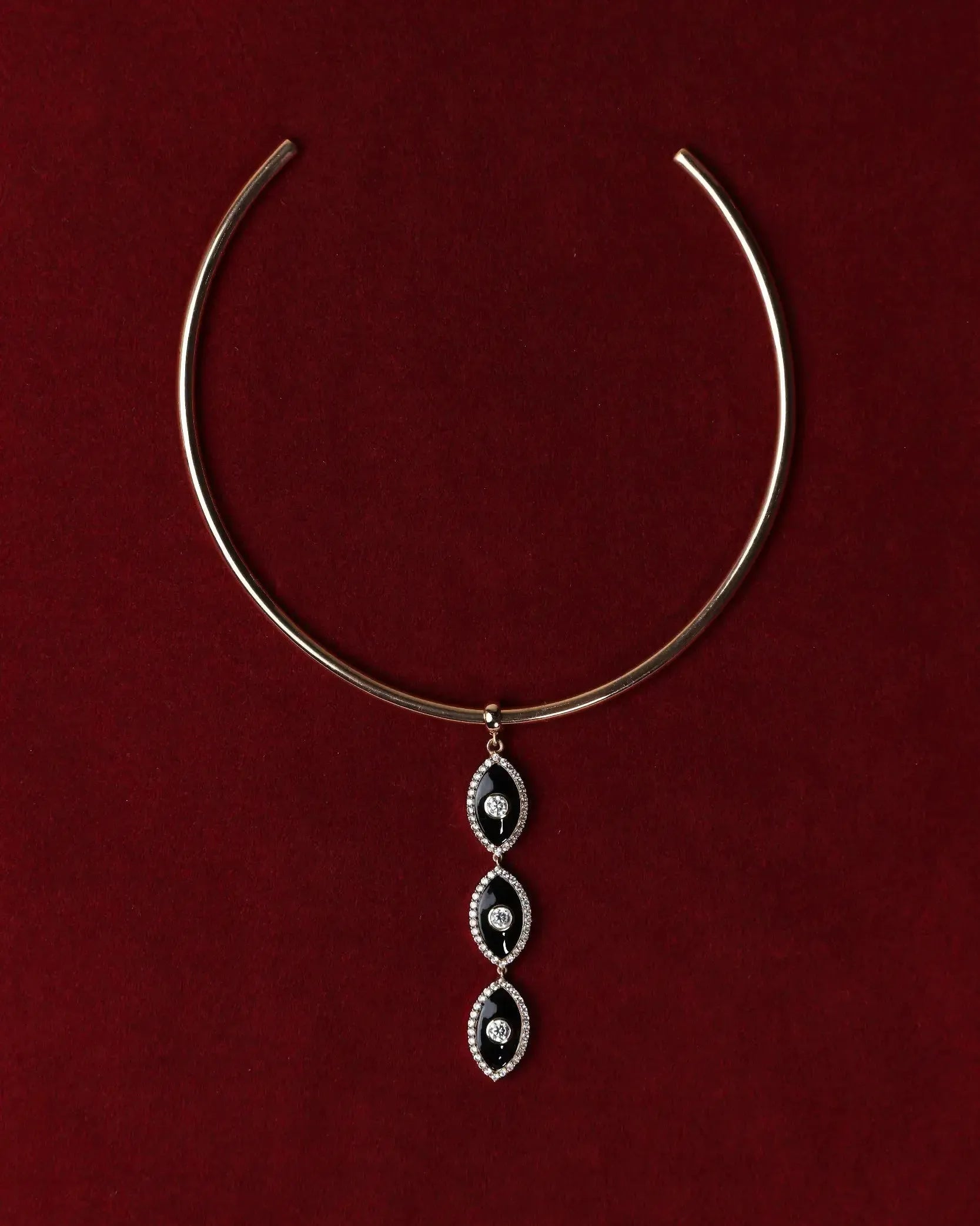 Gold Mayra Evil Eye Choker necklace with a three pendants on a red background