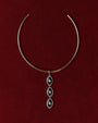 Gold Mayra Evil Eye Choker necklace with a three pendants on a red background