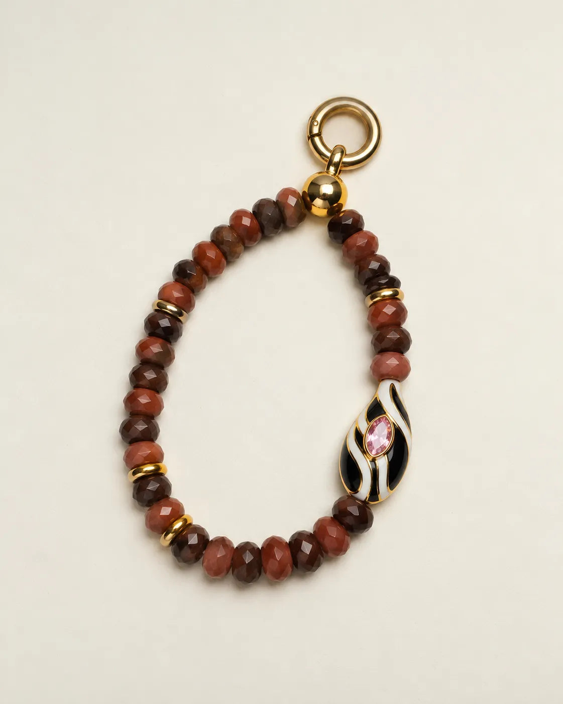 Espresso Mini Minou Bag Charm displayed in a loop with rich brown quartz beads, polished gold accents, and a decorative zebra evil eye bead.