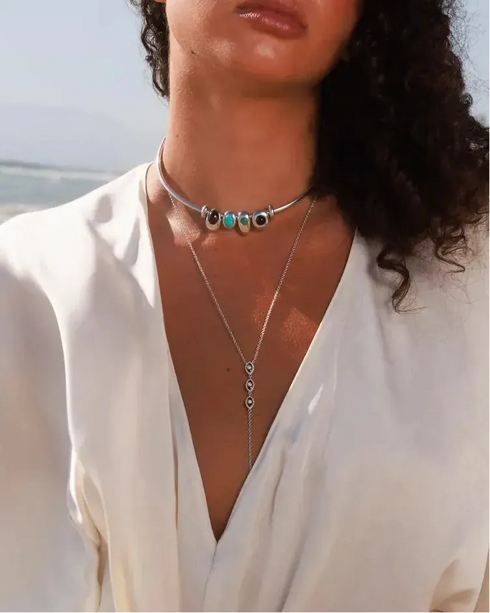 Model wearing MyAleph Large Pampelonne Denim Pouch with mini turquoise phone charm, Terre Choker Necklace, and Mayra Body Chain in a summer beach look