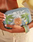 Model holding MyAleph Midi Pampelonne Denim Pouch with embroidered sun and palm design, styled with Riviera Bracelets