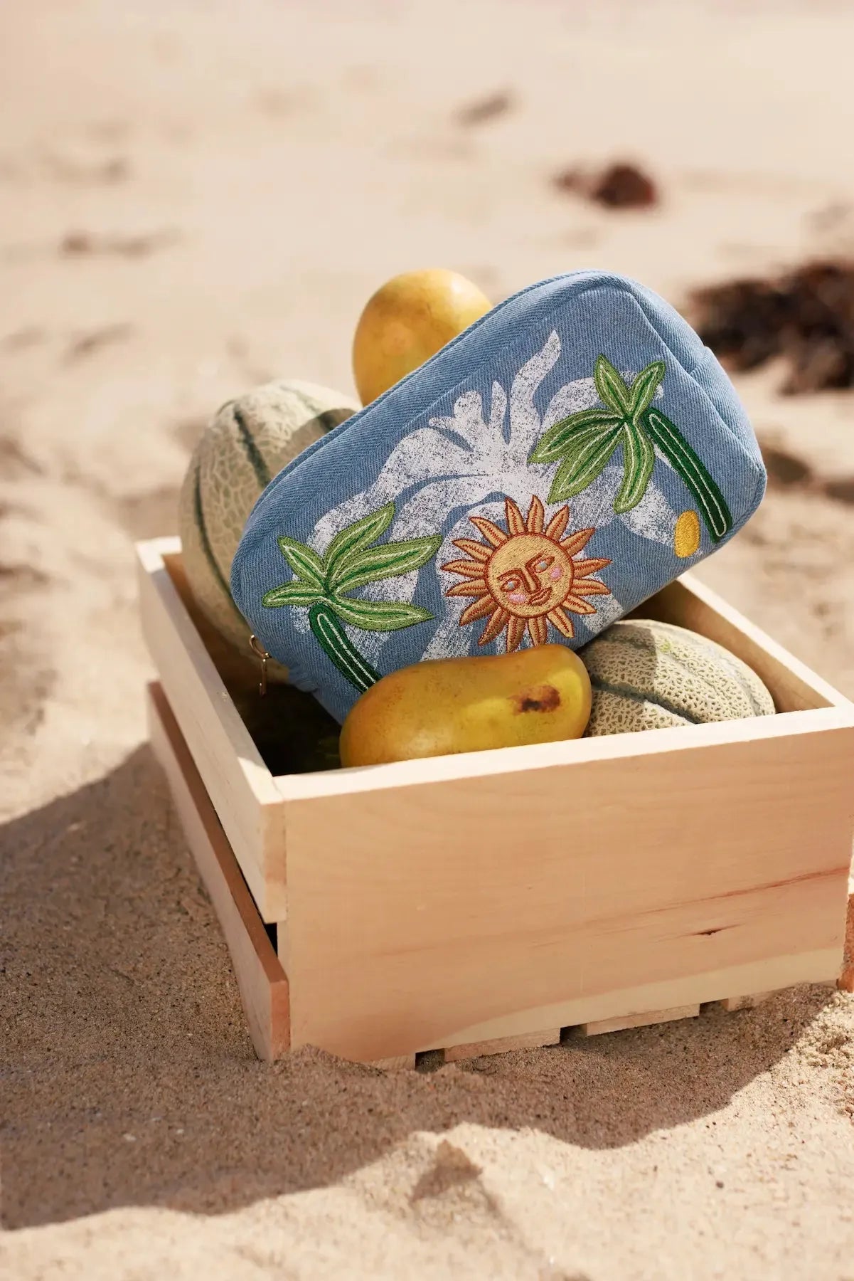 MyAleph Midi Pampelonne Denim Pouch with embroidered Mediterranean sun and palm design styled for summer travel