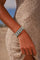 MyAleph Riviera Bracelet in Capri — navy and turquoise evil eye protective charm bracelet worn on wrist, styled with a cream knit summer dress on the beach.