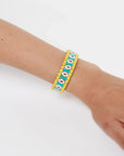 MyAleph Riviera Bracelet on wrist with yellow cotton cord, turquoise enamel details, glossy evil eye design, and adjustable fish-lock clasp
