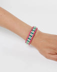 MyAleph Riviera Bracelet on wrist with green and fuchsia cotton cord, glossy enamel evil eye details, and adjustable clasp