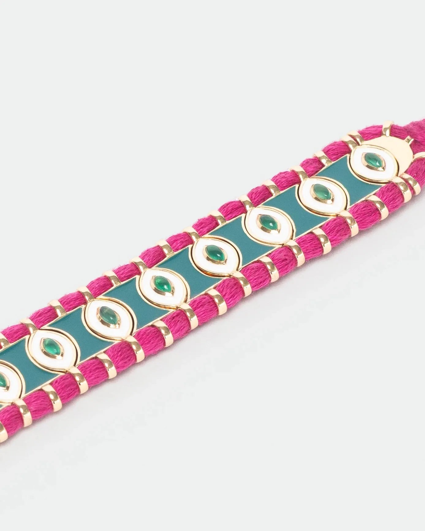 Close-up of MyAleph Riviera Bracelet with green and fuchsia cotton cord, glossy enamel evil eye details, and adjustable closure