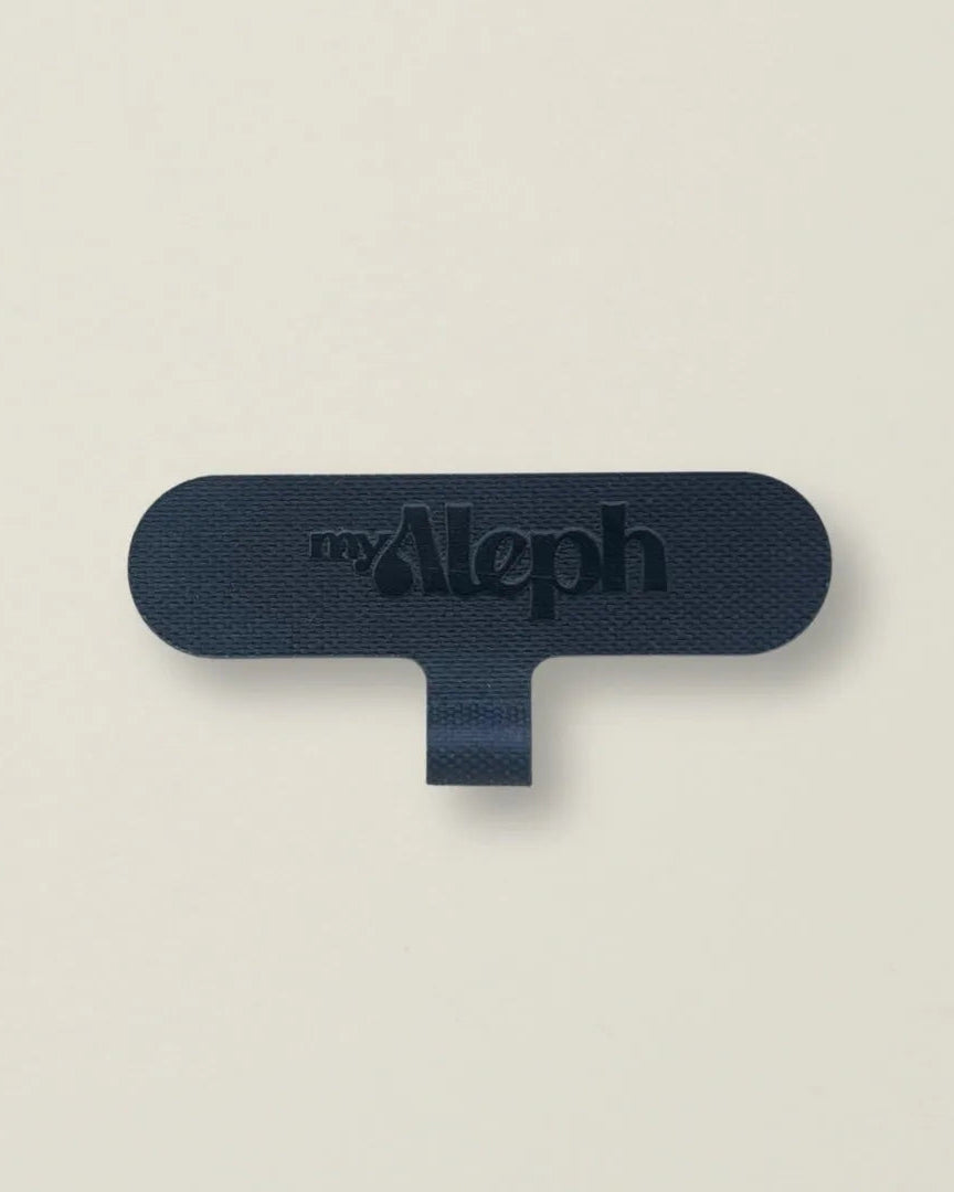 A single black MyAleph Phone Charm Attachment Card against a neutral background, showing its compact and durable design.