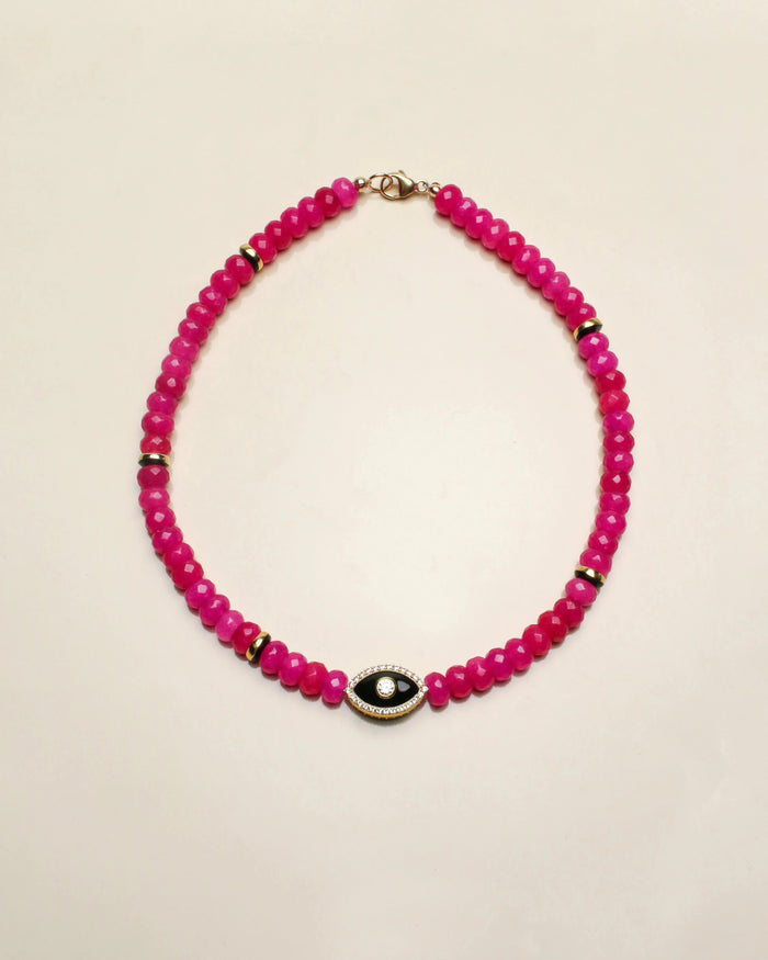 Stella necklace featuring vibrant pink beads with a central evil eye-shaped charm in gold, designed to add a playful and protective touch to any outfit.