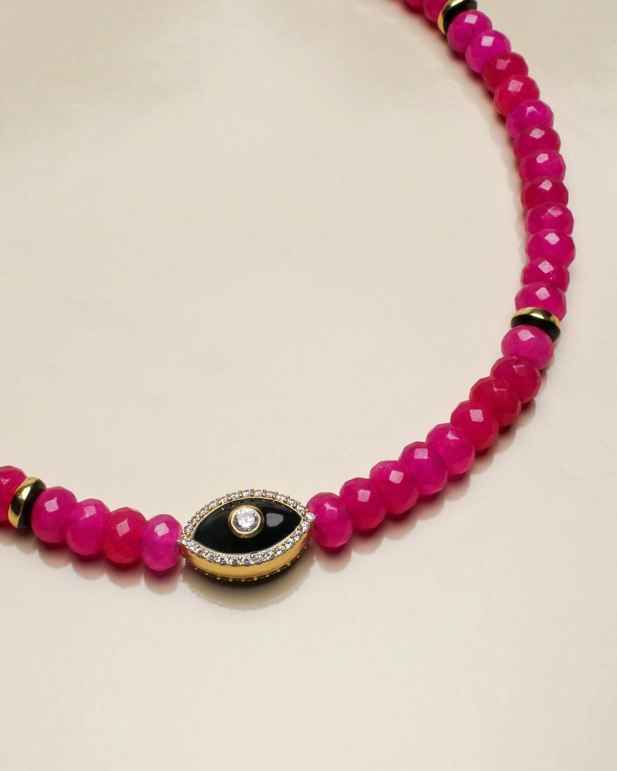 Close-up view of the Stella pink necklace highlighting the bright beads and the evil eye gold charm, a striking accessory for bold style statements.