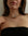 Terre gold choker necklace with turquoise, garnet and onyx charms on model in black top