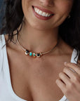 Close-up of model wearing the gold Terre Necklace with interchangeable gemstone charms