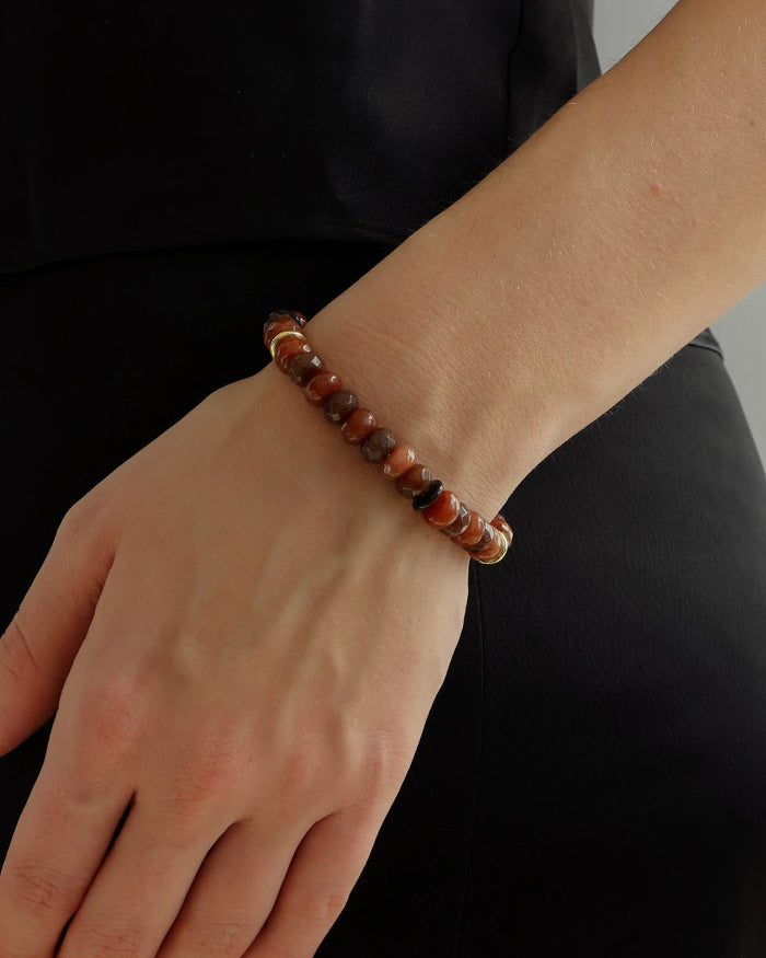 Espresso-toned quartz beaded bracelet with gold accents worn on wrist, brown gemstone bracelet styled with minimalist black outfit