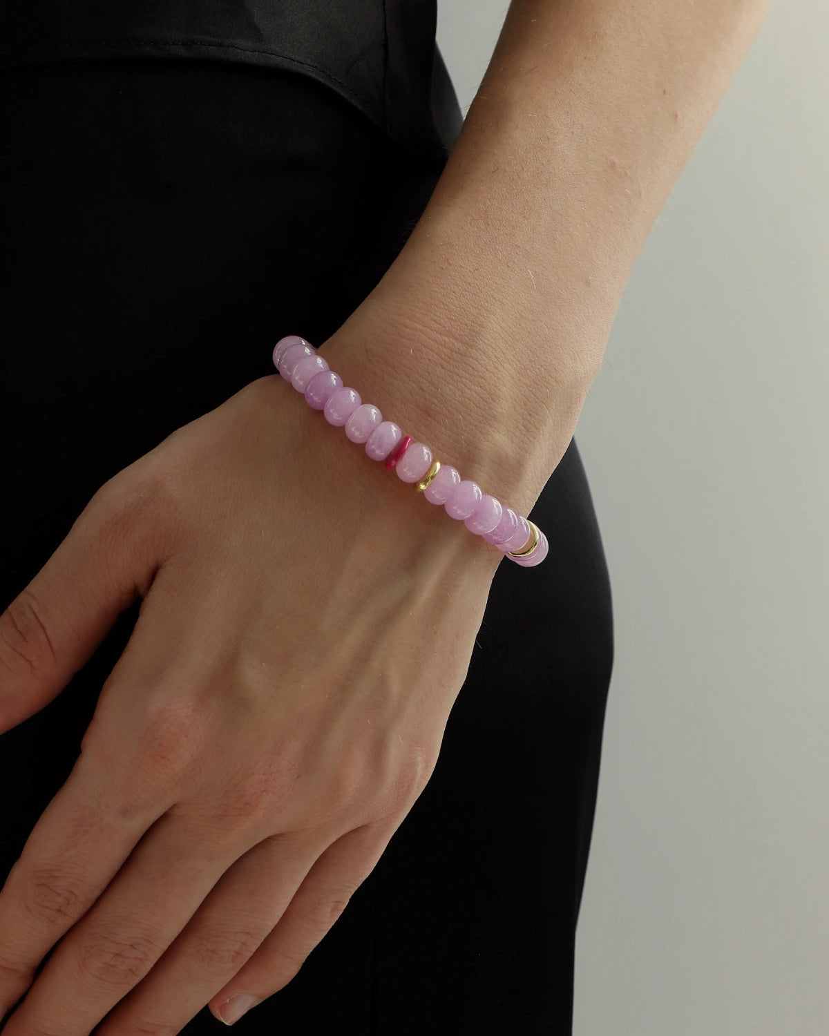 Lavender quartz beaded bracelet with gold accents worn on wrist, soft purple gemstone bracelet styled for everyday layering