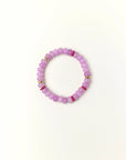 Lavender quartz beaded bracelet with gold spacer details photographed in a full flat lay on a soft cream background