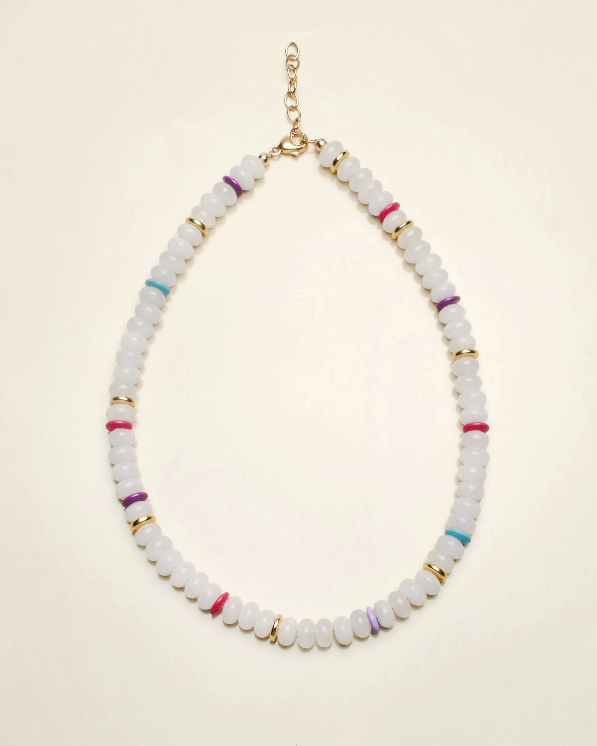 Valerie necklace in white quartz displayed in a flat-lay view, featuring milky white beads accented with multicolored dividers and gold detailing, finished with a delicate chain clasp.