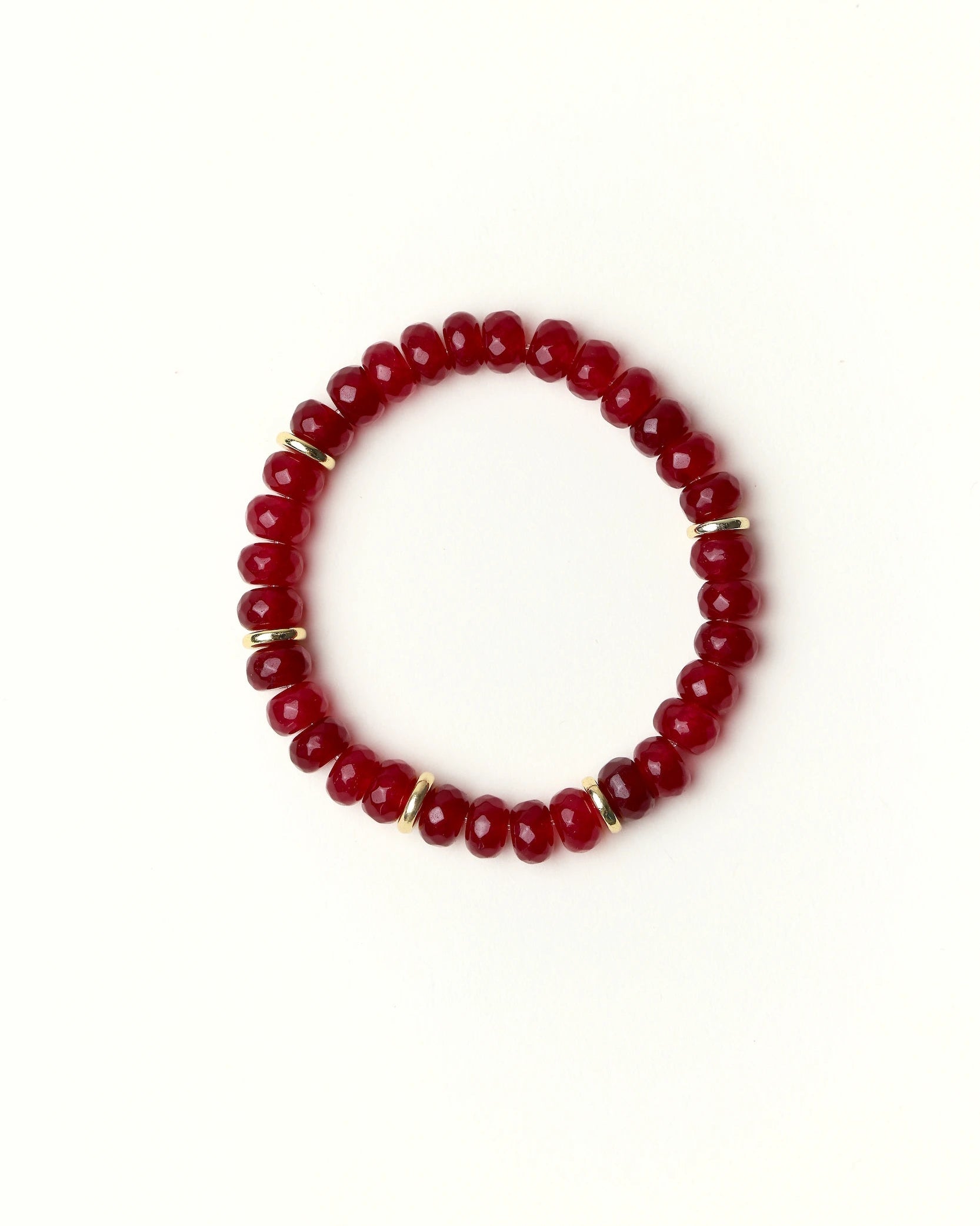 Zoe Ruby quartz beaded bracelet with gold spacer details photographed in a full flat lay on a soft cream background