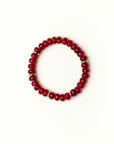 Zoe Ruby quartz beaded bracelet with gold spacer details photographed in a full flat lay on a soft cream background