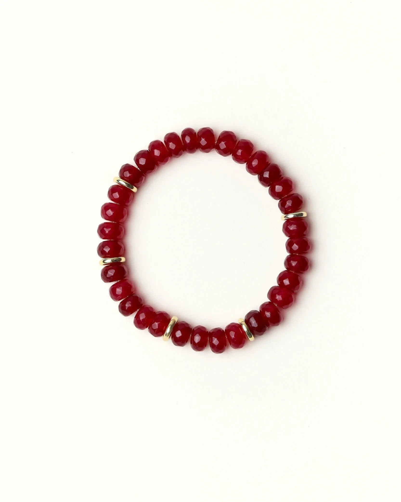 Zoe Ruby quartz beaded bracelet with gold spacer details photographed in a full flat lay on a soft cream background