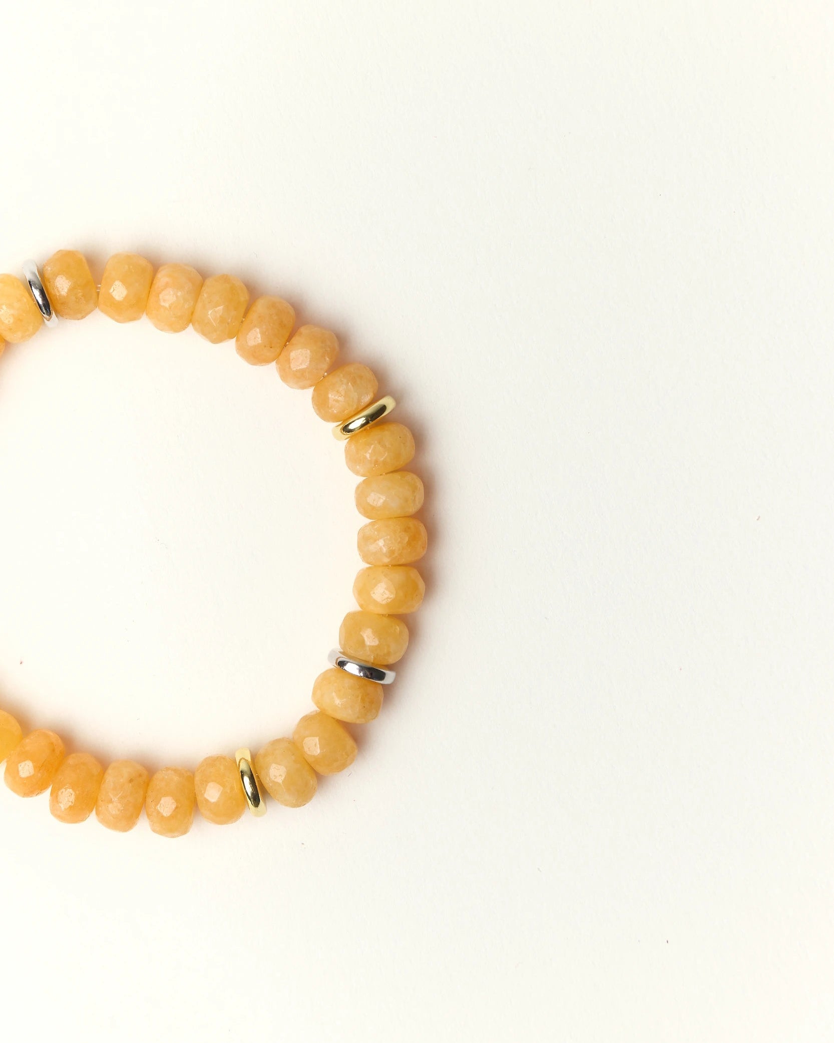 Close-up flat lay of Zoe Azure quartz beaded bracelet with gold spacer accents on a soft cream background