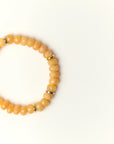 Close-up flat lay of Zoe Azure quartz beaded bracelet with gold spacer accents on a soft cream background