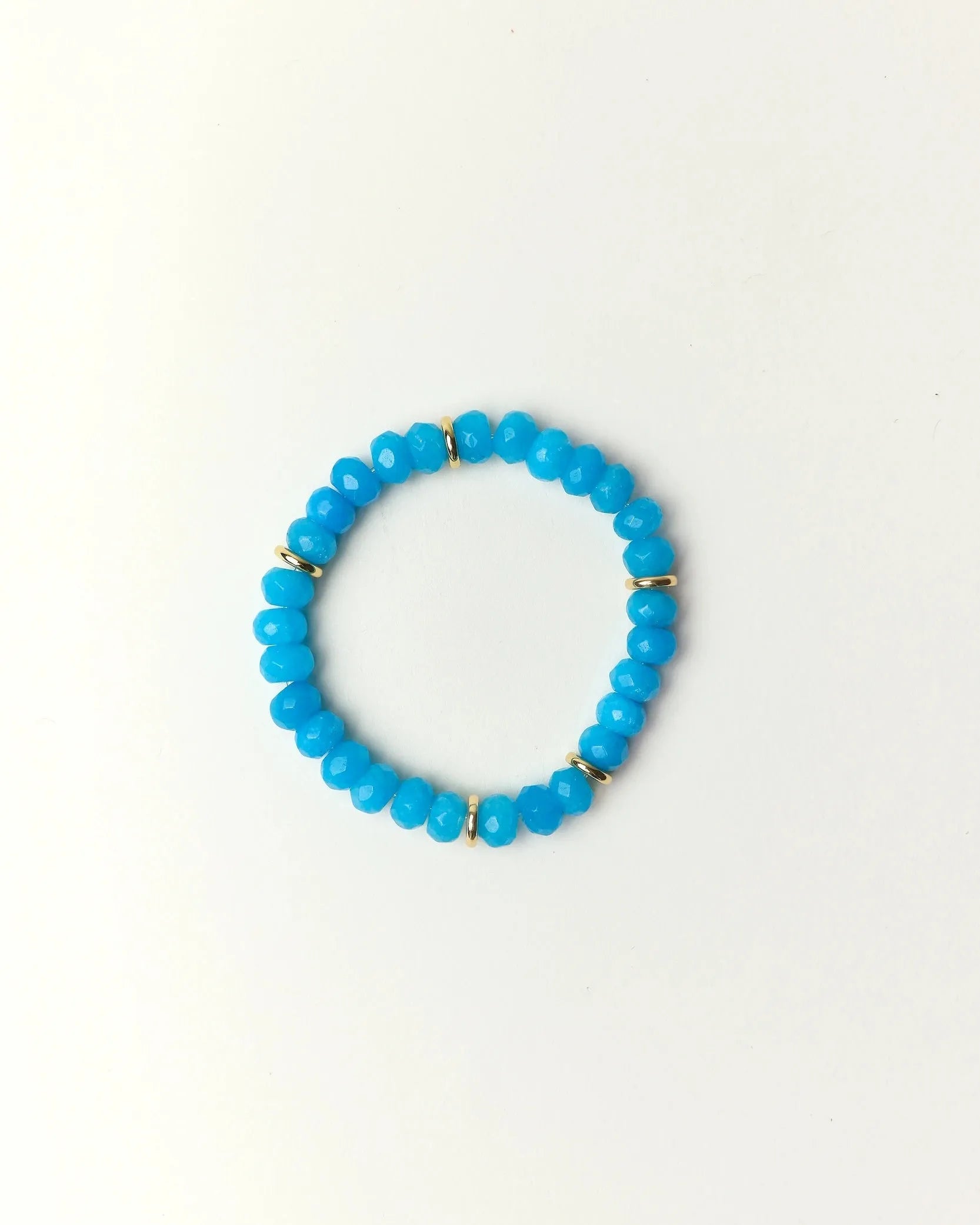 Zoe Azure quartz beaded bracelet with gold spacer details photographed in a full flat lay on a soft cream background