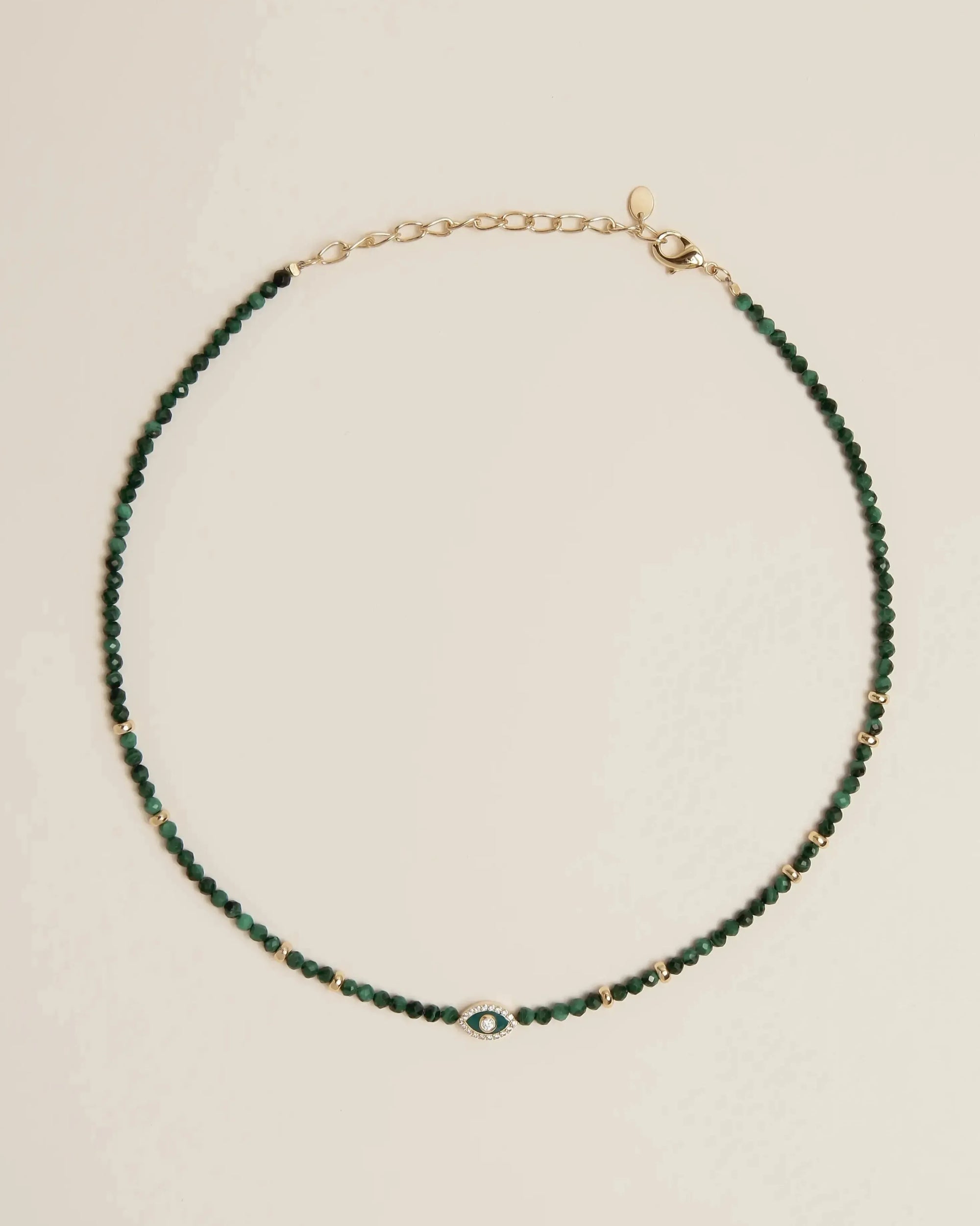 Flatlay of the Juliana Necklace in Malachite, showcasing deep green malachite beads and gold-plated adjustable clasp.