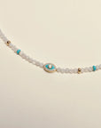 Close-up of the Juliana Necklace in Moonstone, highlighting the turquoise enamel evil eye charm and delicate gold accents.