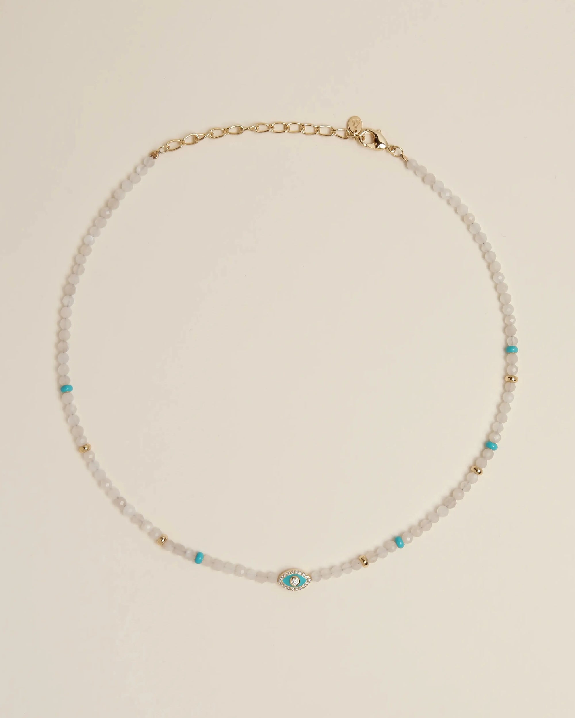 Flatlay of the Juliana Necklace in Moonstone, featuring luminous moonstone beads, turquoise evil eye charm, and gold-plated adjustable clasp.
