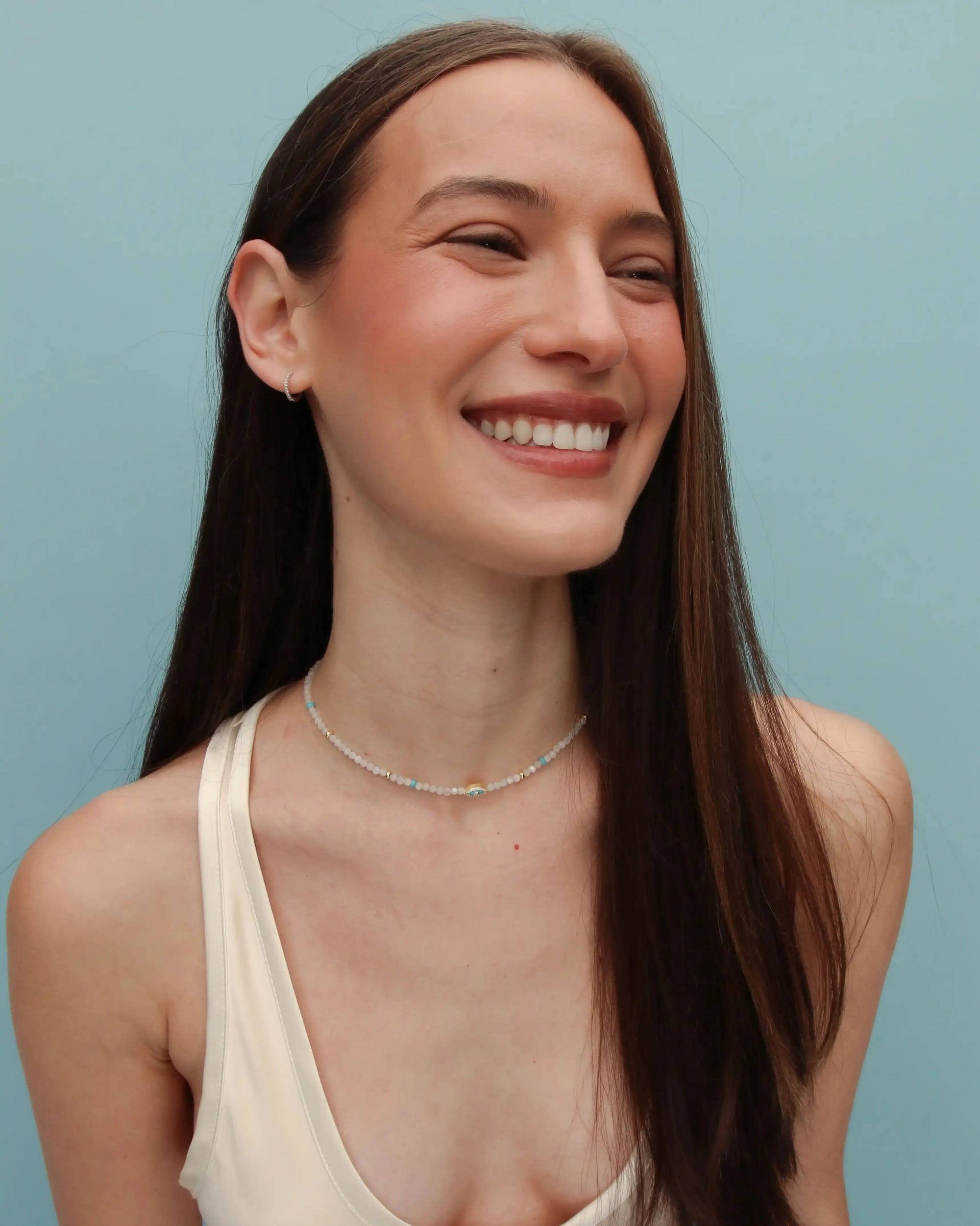 Model wearing the Juliana Necklace in Moonstone with a sleeveless white top, showcasing the light-catching iridescence of the beads.