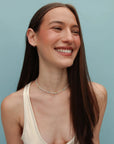Model wearing the Juliana Necklace in Moonstone with a sleeveless white top, showcasing the light-catching iridescence of the beads.