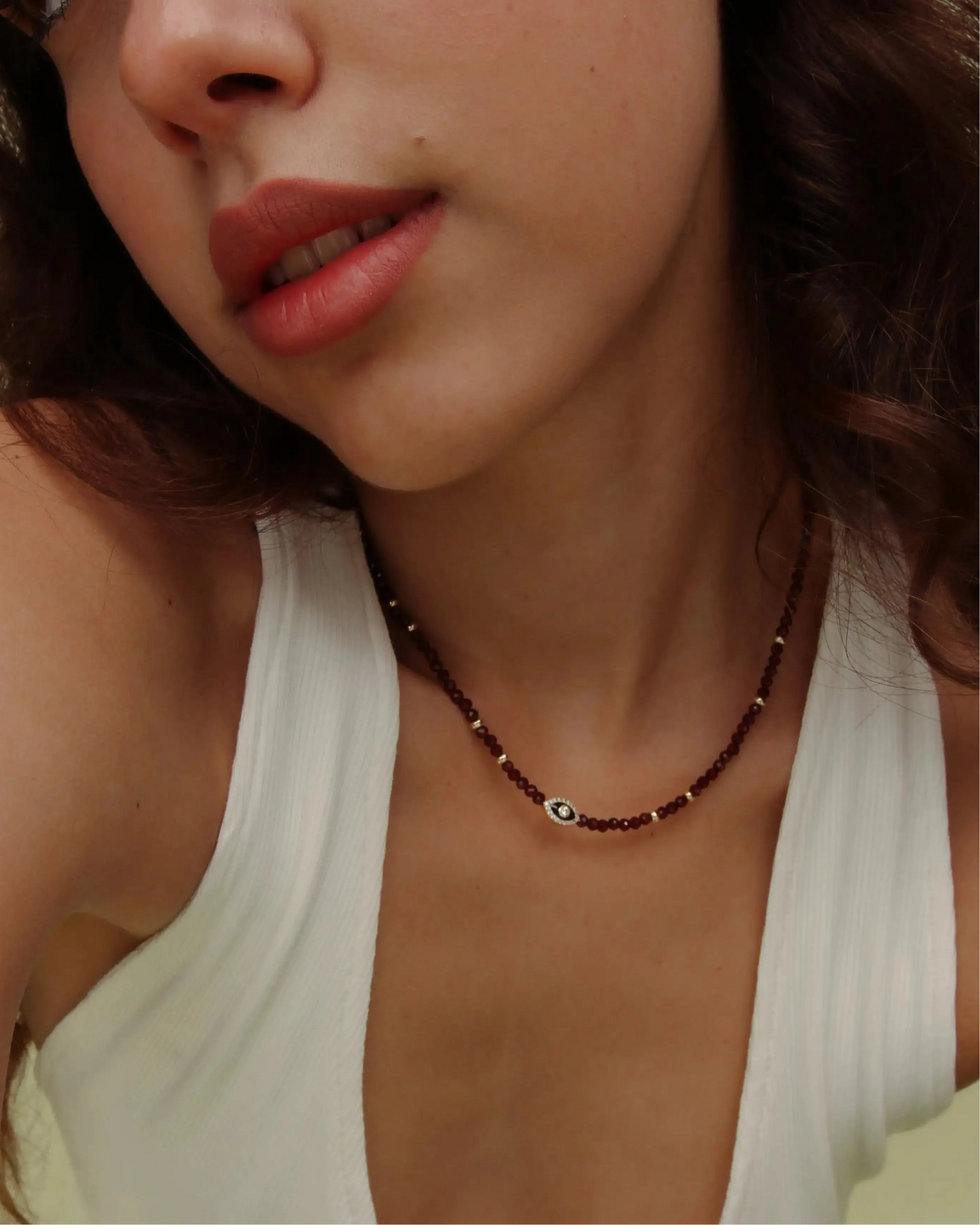 Model wearing the Julianna Necklace in Garnet with a white tank top, showing the bold gemstone contrast against everyday style.