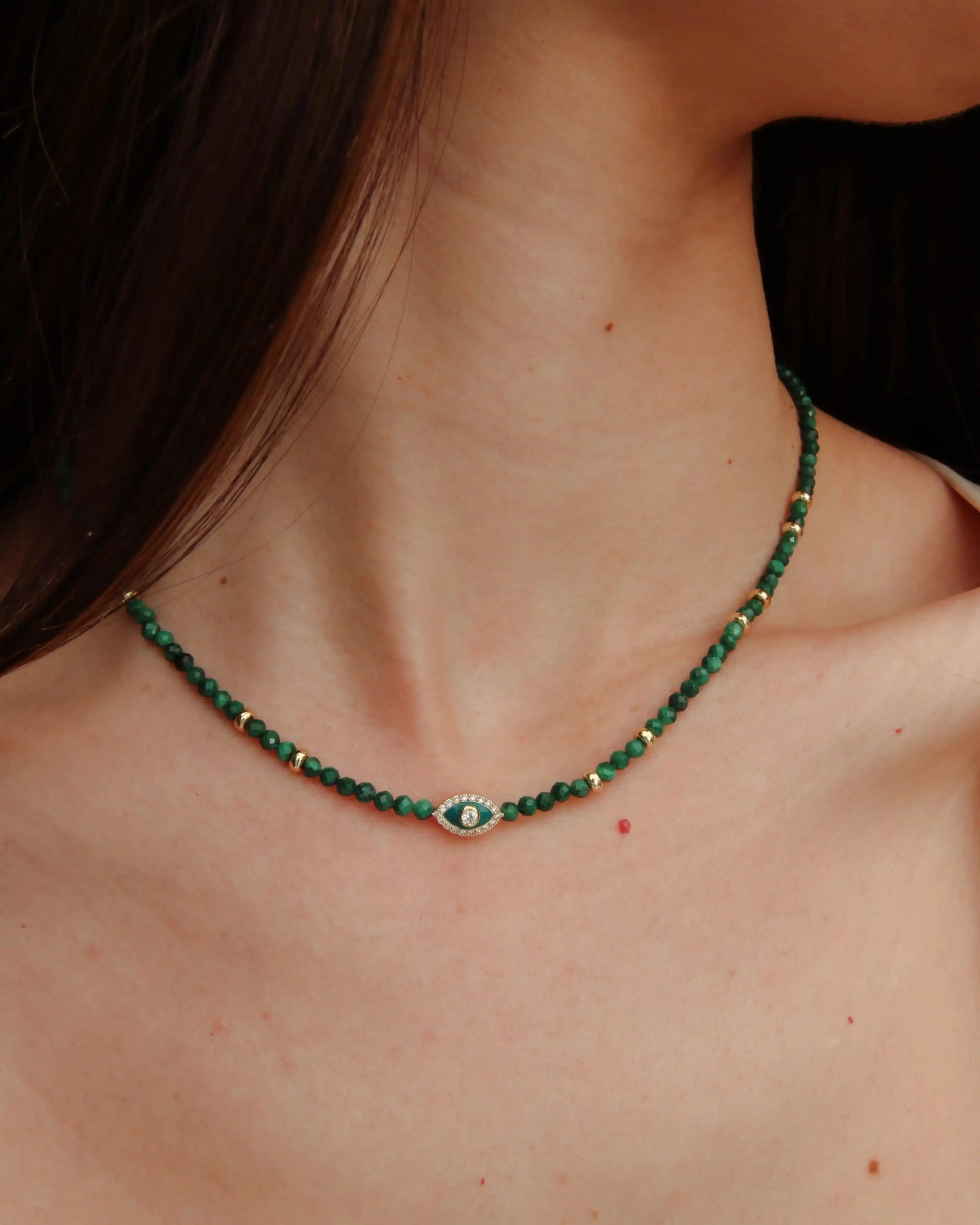Side view of model wearing the Julianna Necklace in Malachite, showing how the necklace contours the neckline.
