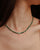 Side view of model wearing the Julianna Necklace in Malachite, showing how the necklace contours the neckline.