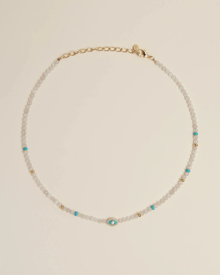 Flatlay of the Julianna Necklace in Moonstone, featuring luminous moonstone beads, turquoise evil eye charm, and gold-plated adjustable clasp.