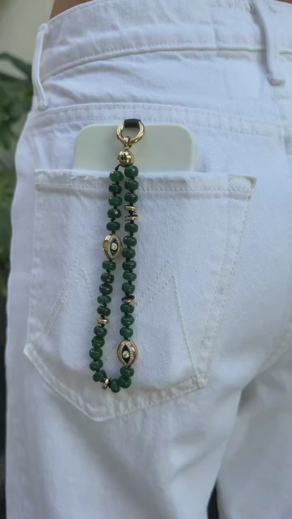 model using the emerald leah phone charm with evil eye charms